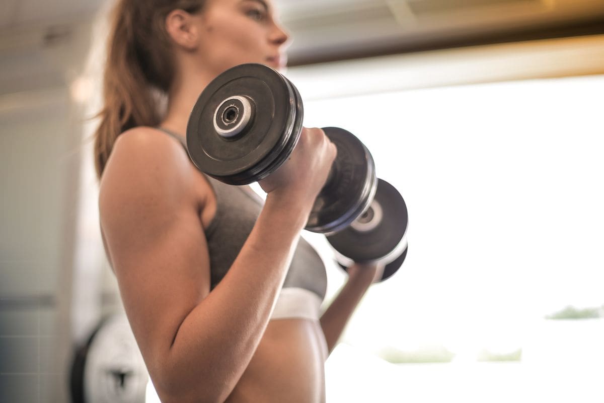 Woman strength training with dumbbells, creatine for women benefits